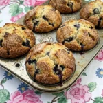Bakery Style Blueberry Muffins with tall golden tops and visible blueberries