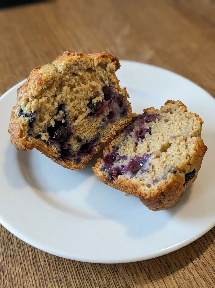 Single Bakery Style Blueberry Muffin split open on plate