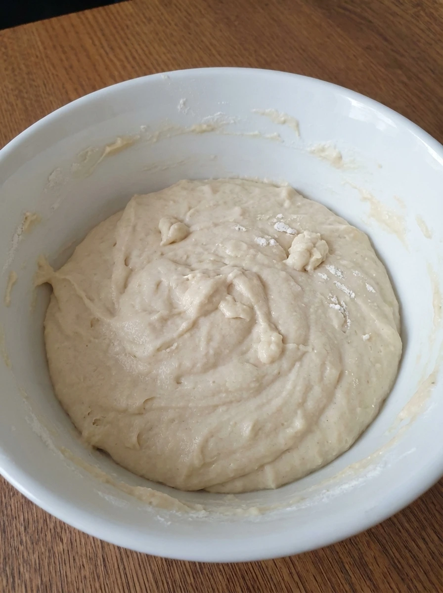Thick biscuit batter with soft ripples in a white dish