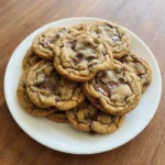 Soft Chocolate Chip Cookies on a white plate with golden edges and soft centers.