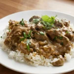 Crockpot Beef Tips and Gravy finished dish with tender beef tips and glossy gravy over rice Recipe focus: beef tips and gravy crockpot easy.