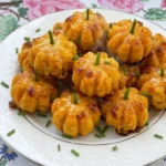 Halloween Appetizers Pumpkin with golden pumpkin shaped cheese bites on a plate