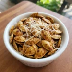Roasted Pumpkin Seeds with Parmesan Cheese piled in a bowl with crisp golden shells and freshly grated Parmesan