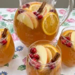 Thanksgiving Cocktail Party Food golden apple cider punch with apple slices and cinnamon