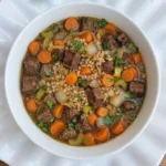 Crockpot Beef Barley Soup with tender beef, pearled barley and vegetables in a deep serving bowl Recipe focus: beef barley soup in crockpot.