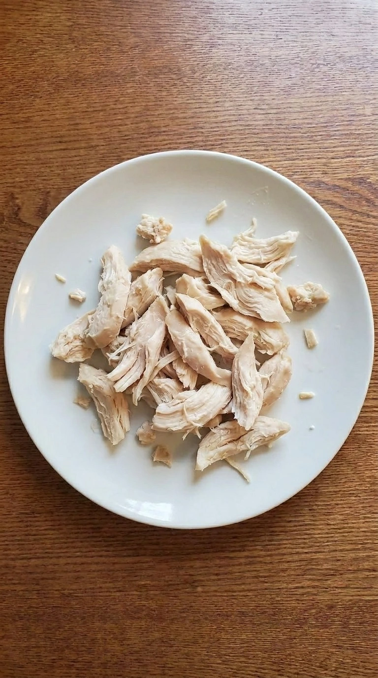 Crockpot Chicken and Wild Rice Soup step showing 2 chicken breasts shredded into moist irregular pieces Recipe focus: chicken and wild rice soup crockpot.