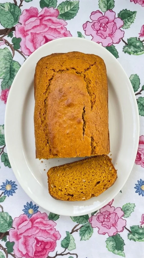 Gluten Free Pumpkin Bread Almond Flour loaf with a golden crust and moist orange sliced crumb.