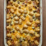 Tater Tot Breakfast Casserole with golden tater tots and melted cheddar in baking dish Recipe focus: breakfast casserole with hashbrowns.
