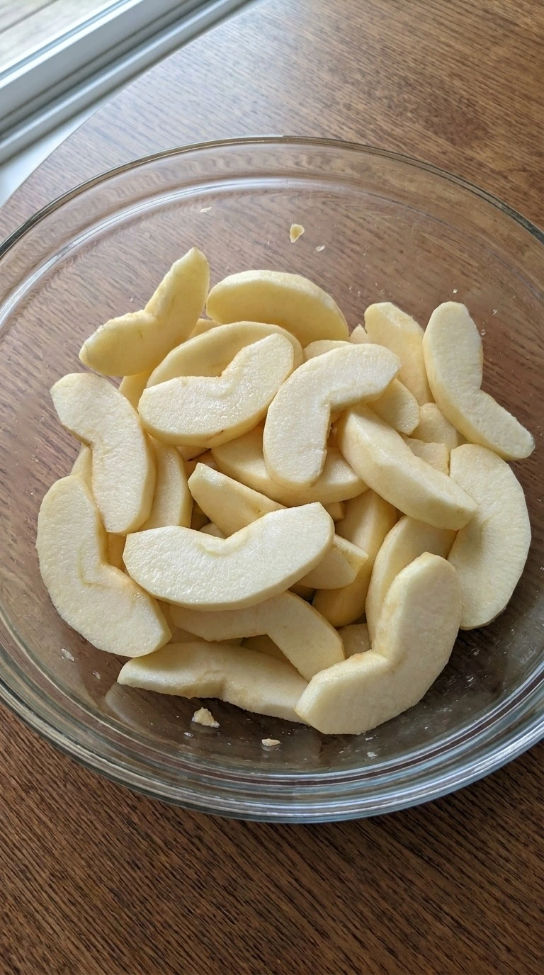 Apple Crumble Pie preparation with peeled Granny Smith and Honeycrisp apple slices in a mixing bowl. Recipe focus: easy apple crumble pie.