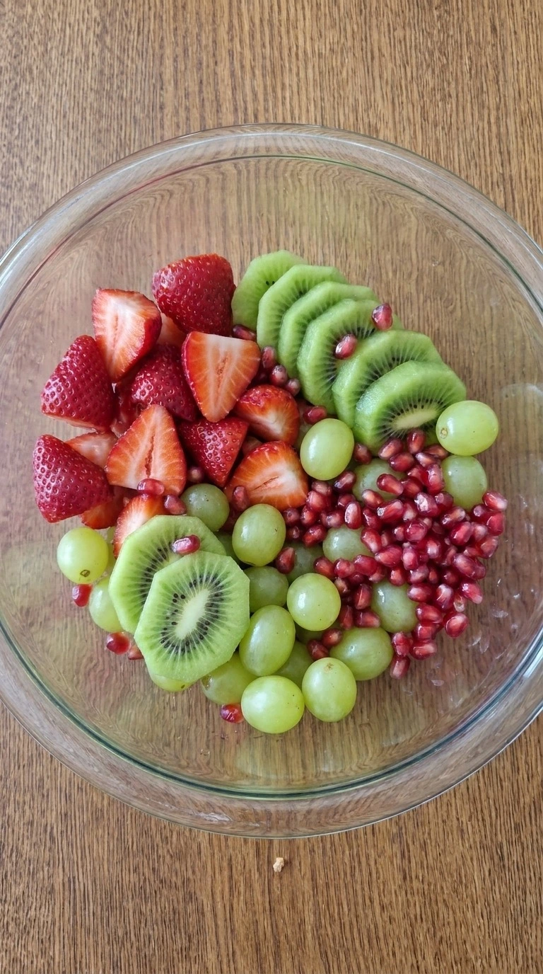Christmas Fruit Salad mixture with red strawberries, green kiwi, whole grapes and ruby pomegranate arils Recipe focus: christmas salad.