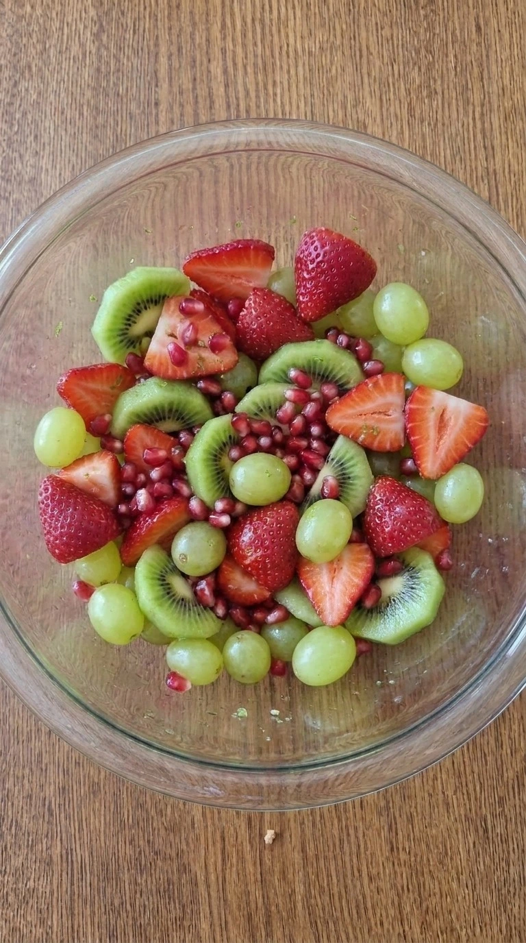 Christmas Fruit Salad being gently coated with honey lime dressing while the red and green fruit stays intact Recipe focus: christmas salad.