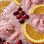 Christmas Sherbet Punch with pink raspberry sherbet foam, orange slices and cranberries in a glass punch bowl Recipe focus: christmas punch with sherbet.