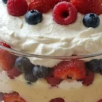Christmas Trifle layered with vanilla pound cake, custard, strawberries, raspberries and whipped cream in a glass bowl Recipe focus: christmas trifle easy.