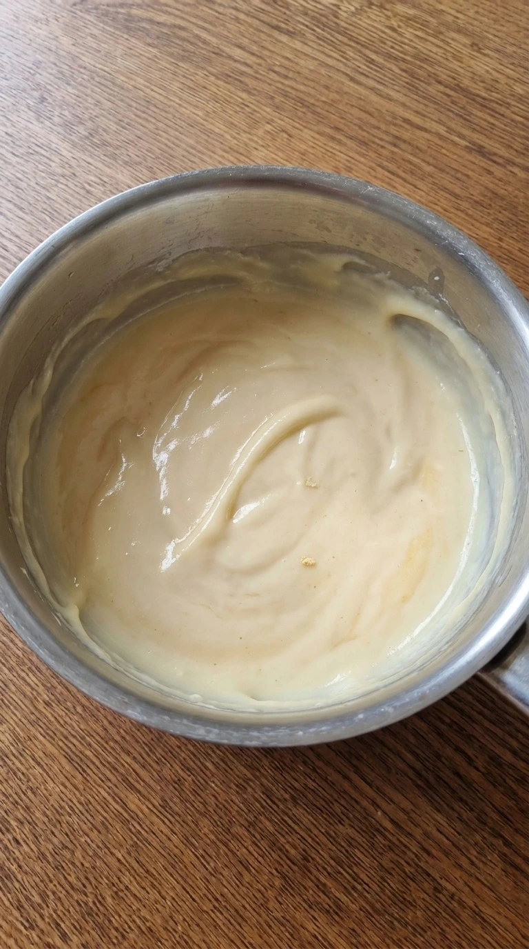 Christmas Trifle vanilla custard thickened to a glossy pale cream consistency in a saucepan Recipe focus: best trifle christmas.