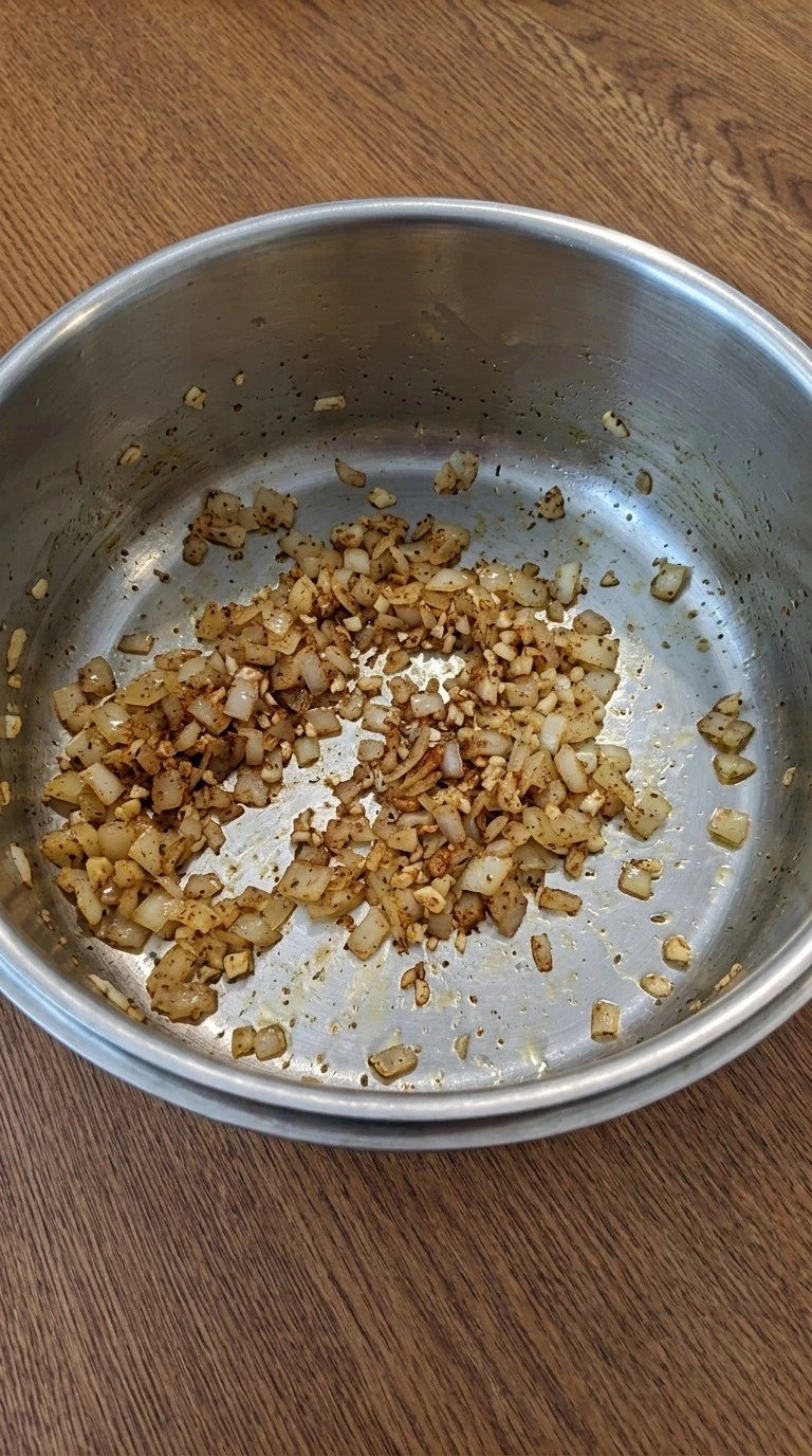 Creamy White Chicken Chili step one showing softened onion, garlic and toasted spices in a pot. Recipe focus: instant pot white chicken chili.