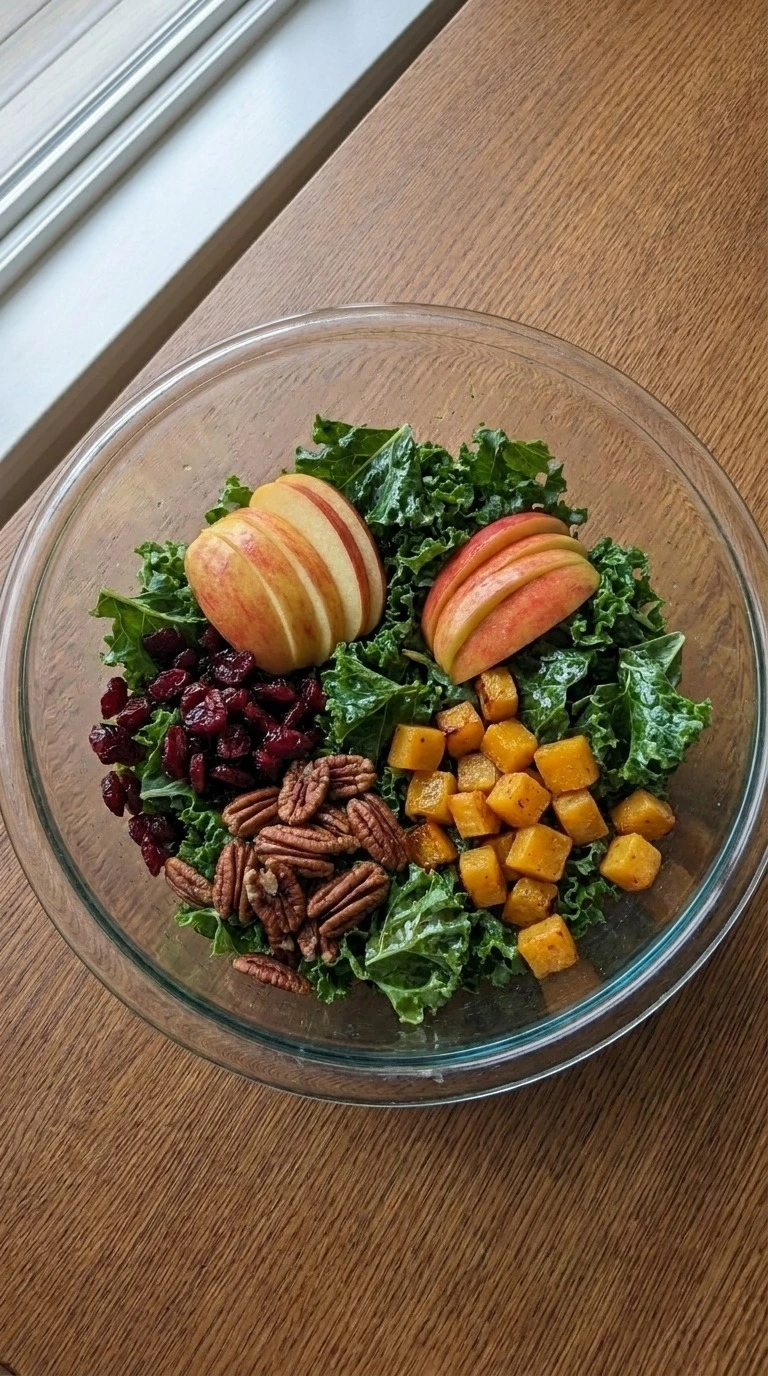 Fall Harvest Salad mixed kale apples squash cranberries and pecans in bowl Recipe focus: fall kale salad.