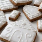 Gingerbread House Cookies with golden edges and royal icing decorations Recipe focus: gingerbread house cookies decorated.