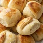 Parker House Rolls with golden buttery folded tops and soft fluffy centers arranged on a white serving platter Recipe focus: easy parker house rolls.