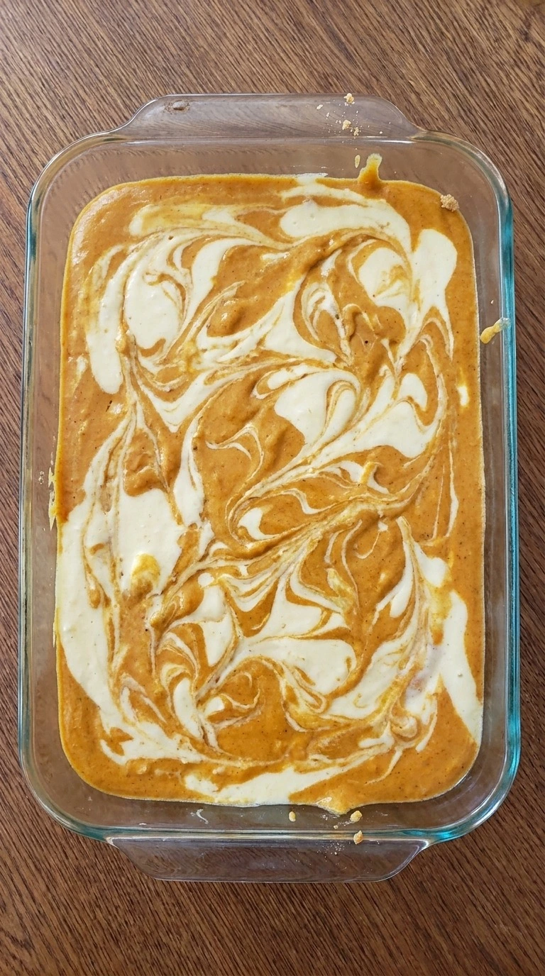 Pumpkin Cheesecake Bars layered pumpkin and cheesecake swirls before baking Recipe focus: pumpkin pie bars.