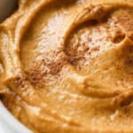 Pumpkin Pie Dip in a serving bowl with creamy orange swirls and cinnamon topping Recipe focus: pumpkin fluff dip.