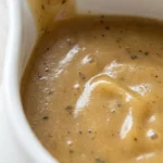 Turkey Gravy Without Drippings in a white gravy boat with a rich golden color and smooth buttery texture Recipe focus: easy turkey gravy without drippings.