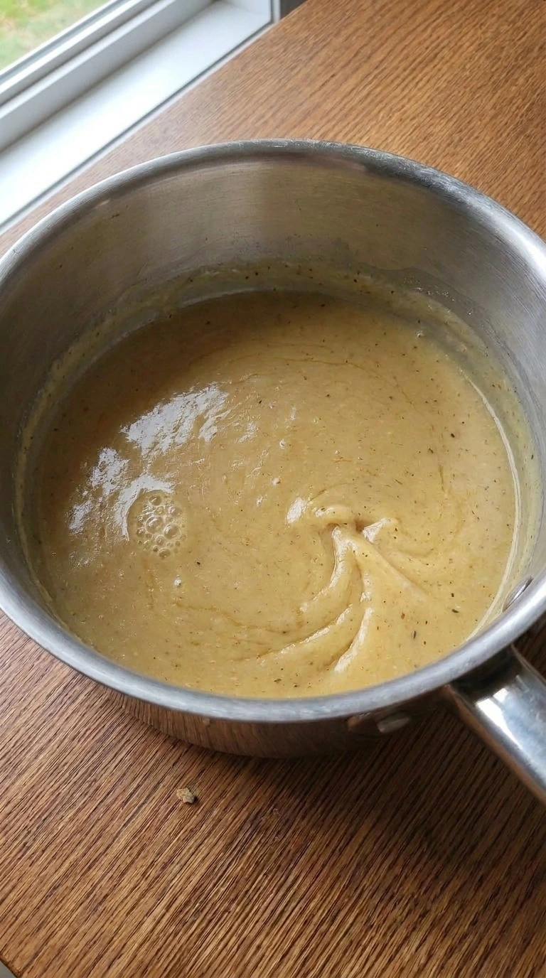 Turkey Gravy Without Drippings step three showing golden gravy thickening with sage, thyme and Recipe focus: thanksgiving turkey gravy without drippings.